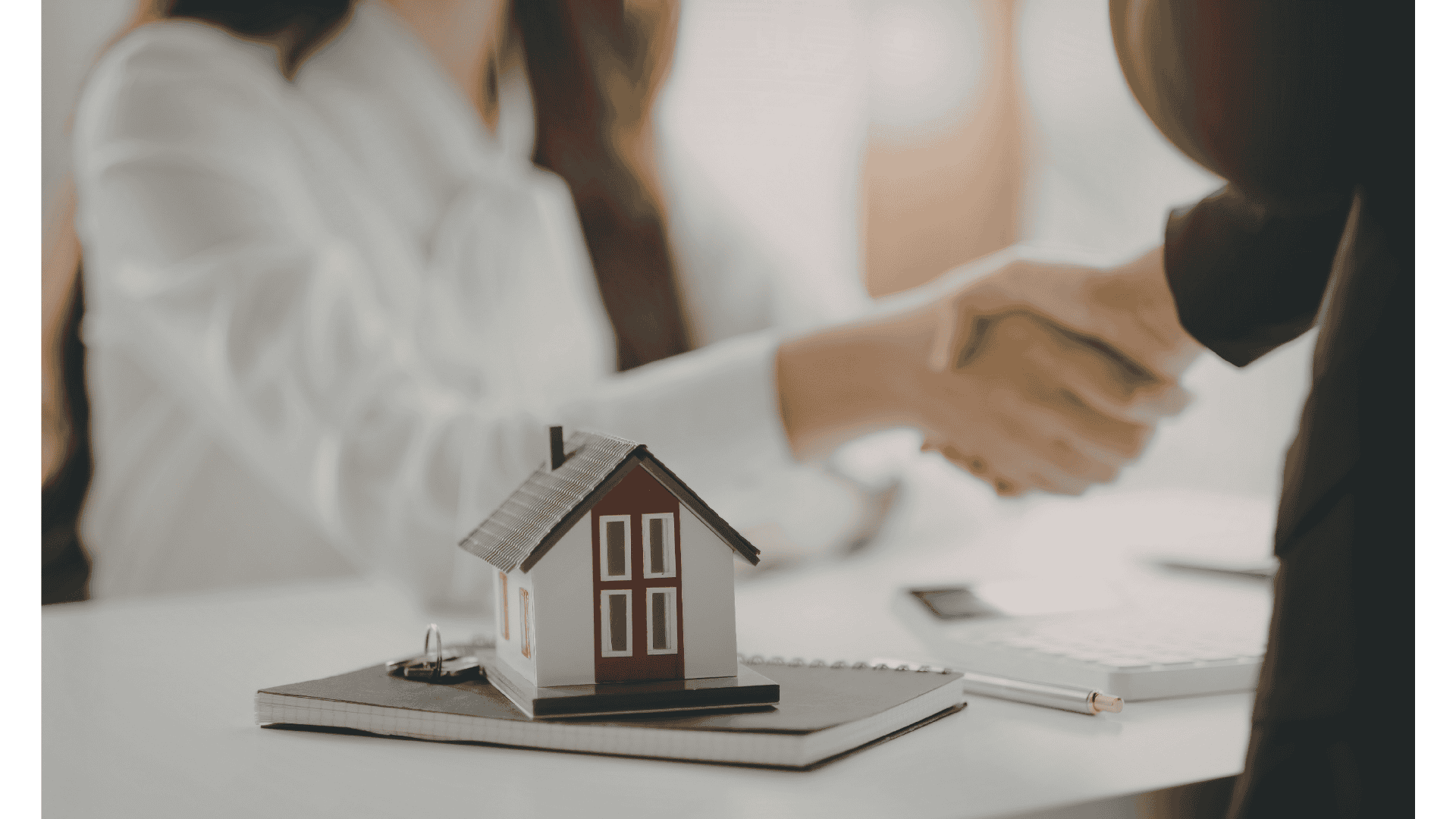 Immobilien privat oder GmbH: Vertragsabschluss beim Immobilienkauf mit Modellhaus und Handschlag